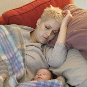 Heather sleeps with her infant daughter.