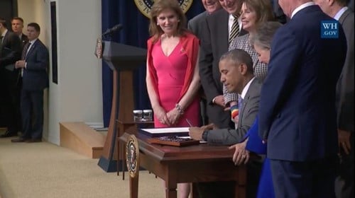 President Obama signing The Lautenberg Chemical Safety Act with a small group of people standing behind and watching him