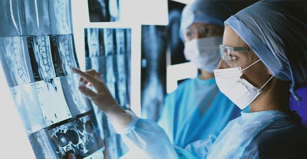 Medical staff wearing masks look at x-rays