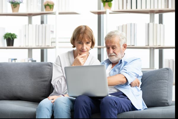 Two individuals researching on the computer.