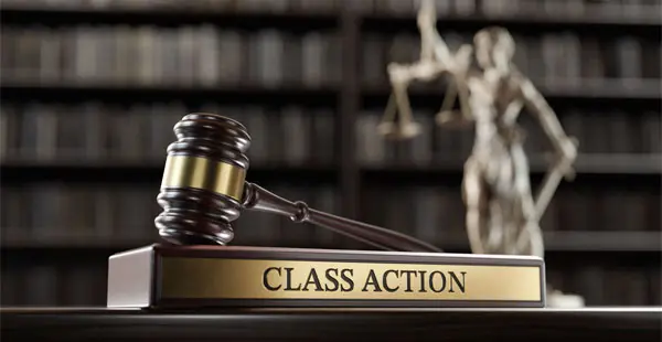 Gavel and Lady Justice statue with a “Class Action” sign
