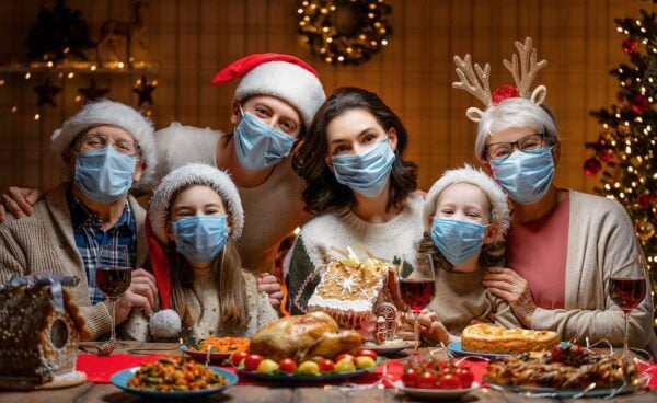 Family with face masks holiday dinner celeration