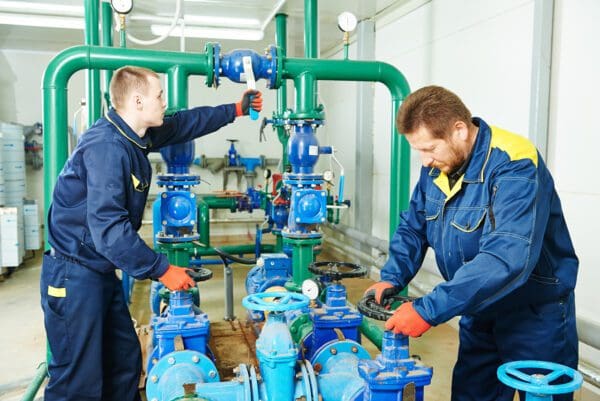 Two men work on boiler equipment