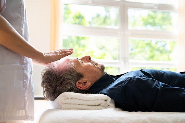 A photo of a man getting a massage after receiving a gift for a free massage to cheer them up after a cancer diagnosis.