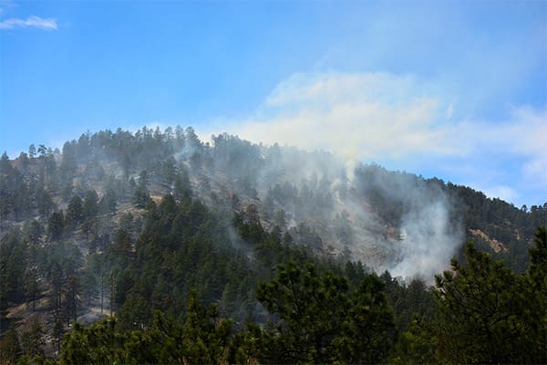 A photo showing a mountain in Montana that has a wildfire burning.