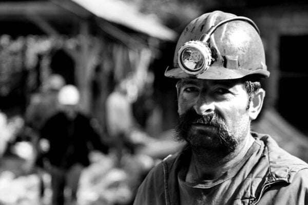 Image depicts a mine worker wearing a hard hat. These workers may have been exposed to asbestos.