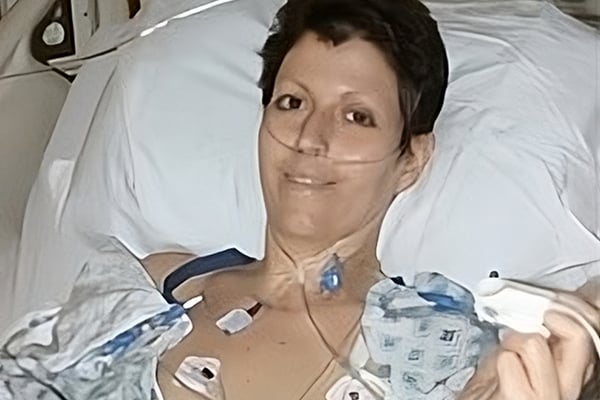 Heather Von St. James lies in a hospital bed, post-surgery.