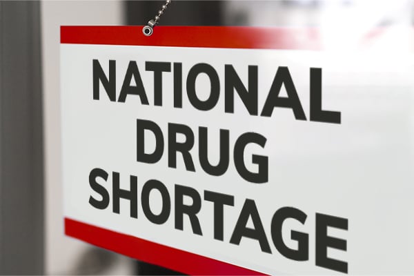 A sign on the outside of an infusion center door reads "CLOSED, National Drug Shortage."