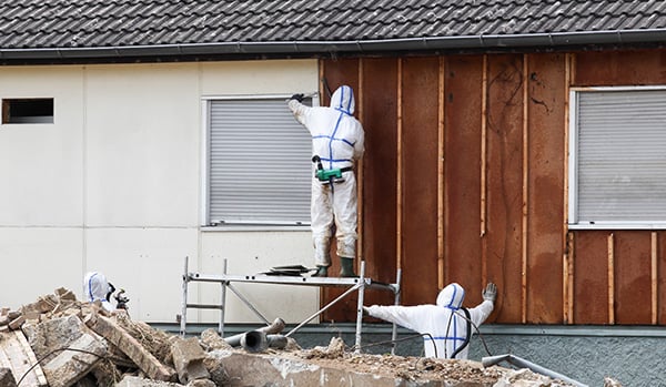Asbestos abatement professionals working on a house