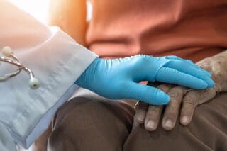 Doctor holding hands with an end-stage mesothelioma patient