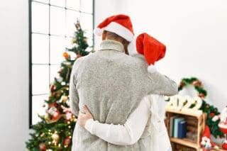 Family members embrace while gazing at holiday decorations