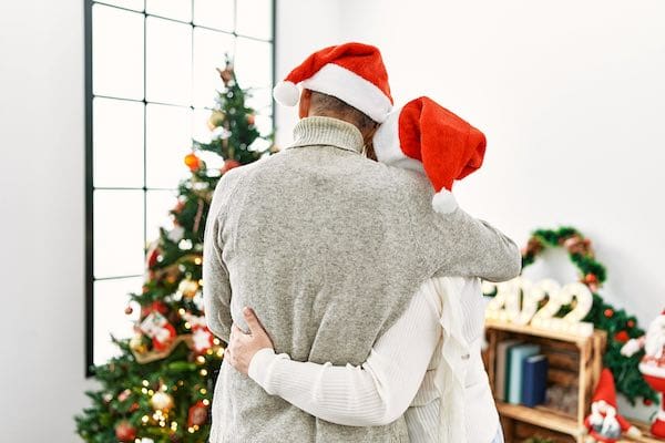 Family members embrace while gazing at holiday decorations